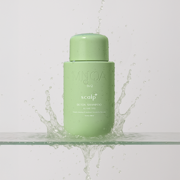 Green shampoo bottle with water splashes on a light gray background
